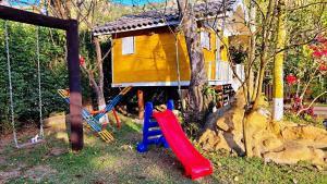圣本图-杜萨普卡伊Chalés Poly的一个带房子和滑梯的儿童游乐场