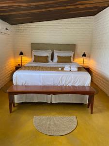 MaxaranguapeCasa Pé na Areia Maracajau的一间卧室配有一张大床和一张木桌