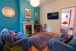 温彻斯特Boscobel Apartments Down的客厅配有2张蓝色沙发和壁炉