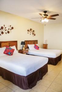 危地马拉安地瓜Nico Hotel的酒店客房配有两张床和吊扇。