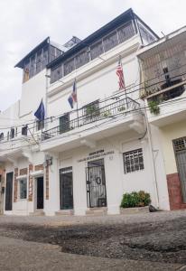 圣多明各Casa de Huespedes Colonial的一座白色的建筑,上面有两面旗帜