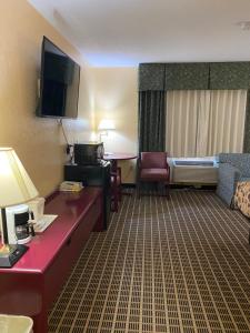 StewartvilleAmerica's Stay Inn Stewartville的酒店客房配有书桌和床,