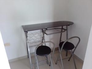 卡塔赫纳Bonito apartamento en Cartagena con garaje gratuito的桌子下方有两张凳子