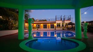 塞班Beach Garden Hotel的一座带绿色柱子的游泳池和一座建筑