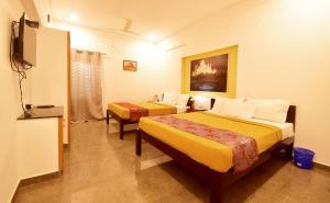 蓬蒂切里BHARATHI RESIDHOME的酒店客房设有两张床和电视。