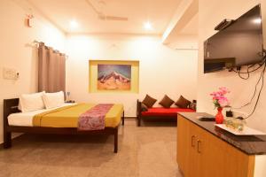 蓬蒂切里BHARATHI RESIDHOME的酒店客房,配有床和沙发