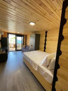 博德鲁姆Bitez Tiny House & Beach的木制客房内的一间卧室配有一张大床