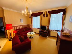 策德尼克Schloss Zehdenick的客厅配有2张红色沙发和电视