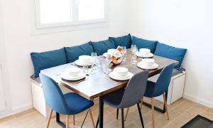 科洛米耶Air'BABY - 1 à 6 PERSONNES - Colomiers Centre的一张带椅子的餐桌和一张蓝色的沙发