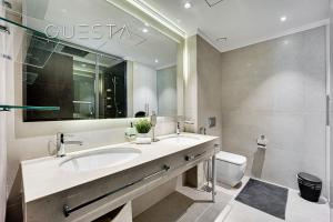 迪拜Marina Promenade, Dubai Marina的一间带水槽、镜子和卫生间的浴室