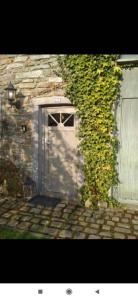 Bras-HautA la Grange d'en Haut的通往常春藤生长的建筑的门