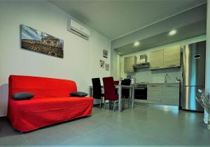 莱切DeA del Salento的一间带红色椅子的客厅和一间厨房