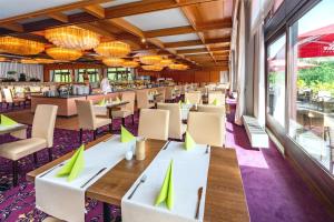 布劳恩拉格AHORN Harz Hotel Braunlage的餐厅配有桌椅和绿色餐巾