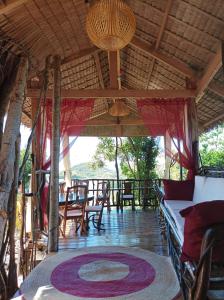 布桑加OcamOcam Azur Inn的门廊配有桌椅和地毯