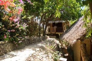 布桑加OcamOcam Azur Inn的一条通往鲜花和树木的房子的小路