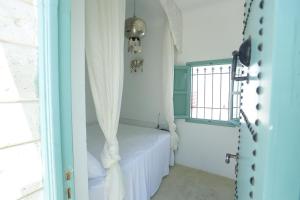 哈马马特Dar Hammamet Guest House & Hammam的配有床、窗帘和窗户的房间