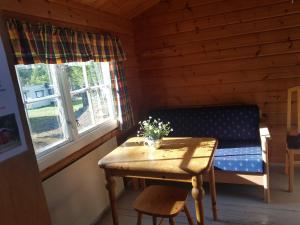 LesjaskogLesjaskogsvatnet Camping的小屋内带桌子和长凳的房间