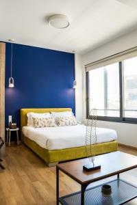 雅典Iasonos Suites Athens的一间卧室设有一张床和蓝色的墙壁