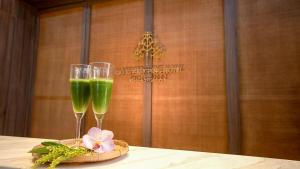 清迈Sareeviengping Hotel Chiangmai的桌子上坐着两杯绿饮料
