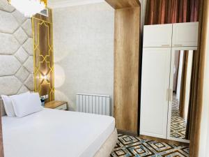 TürkistanKhan Palace的卧室配有白色的床和镜子