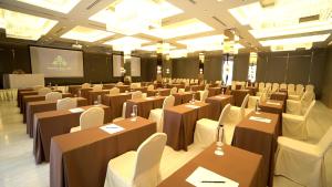 清迈Sareeviengping Hotel Chiangmai的一间会议室,配有桌椅和屏幕