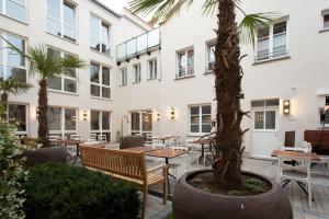 福尔卡赫Hotel Tuchhaus的庭院配有桌椅和棕榈树