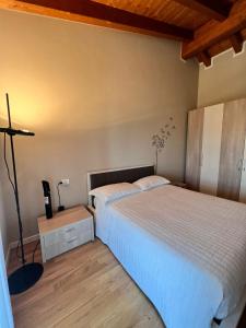 西尔米奥奈Appartamento Corina的一间卧室配有两张床和一盏灯。