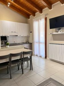 西尔米奥奈Appartamento Corina的一间带桌椅的厨房和一台电视