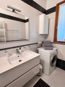西尔米奥奈Appartamento Corina的一间带水槽和洗衣机的浴室