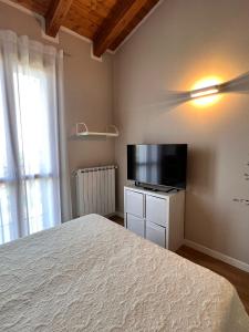 西尔米奥奈Appartamento Corina的一间卧室配有一张床和一台平面电视