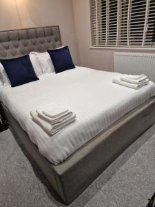 KentLinx View 4 Bedroom House的一张配有白色床单和蓝色枕头的大床