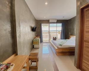 春蓬瓦里奇度假村的一间卧室配有一张床、一张桌子和一个窗户。