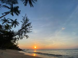 Haad Son秘密海滩别墅度假屋的棕榈树海滩上的日落