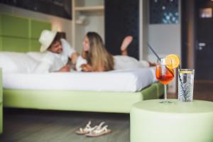利莫内-苏尔加达拉菲奥里塔酒店的一张桌子,喝了一杯,一对夫妇睡在床上