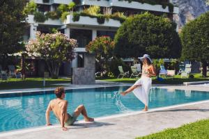 利莫内-苏尔加达拉菲奥里塔酒店的女人和男人跳进游泳池