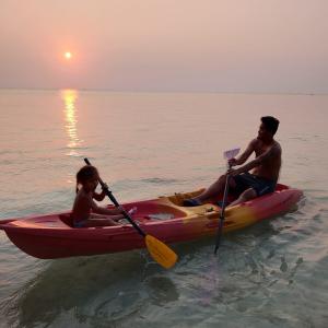 Haad Son秘密海滩别墅度假屋的水中划皮艇的男人和孩子