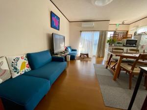 大岛ホライゾン的一间带蓝色沙发的客厅和一间用餐室