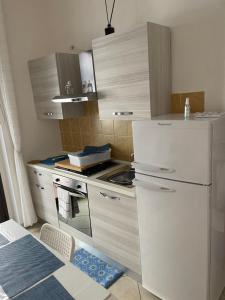 索威拉托玛里纳Corso Umberto Apartment的厨房配有白色冰箱和炉灶。
