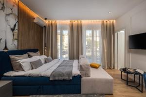 里耶卡Bella Vita Apartments的一间卧室配有蓝色的沙发和一台电视机