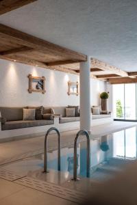 奥蒂塞伊Residence Cesa Sassela的一个带沙发和桌子的房间的游泳池