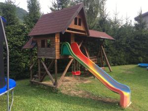特尔乔夫Chalupa pod lipami的一个带房子和滑梯的游乐场