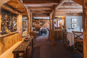 谷雪维尔La Maison Les Peupliers的餐厅拥有木墙和木桌及椅子