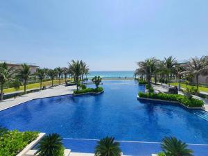 芽庄Luxury villa trong Whyndham garden Cam Ranh的一座棕榈树和海洋的大型游泳池