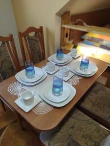 特尔乔夫Chalupa pod lipami的一张木桌,上面有盘子和玻璃杯