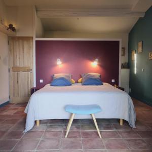莫尔斯chambre d'hôtes Et Puis Voilà!的一间卧室设有一张大床和一张蓝色凳子