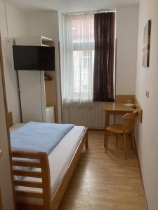 维也纳普瑞博特酒店的一间卧室配有一张床、一张桌子和一个窗户。