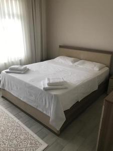 Doğa apart的卧室里一张带两条毛巾的床