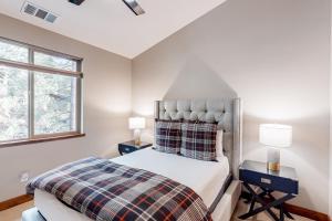 南太浩湖Luxury Escape at Thunderbird的一间卧室配有带2个床头柜和2个窗户的床