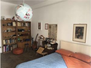 米兰camera in via Tolstoi的一间卧室设有一张床和一个书架