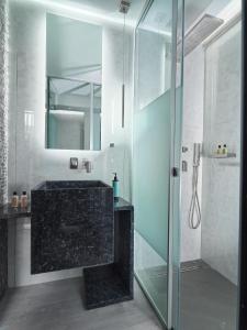 罗希姆诺Nautilux Rethymno by Mage Hotels的一间带玻璃淋浴和水槽的浴室